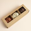Trio of neutral paper pumpkin decorations displayed inside a kraft window box