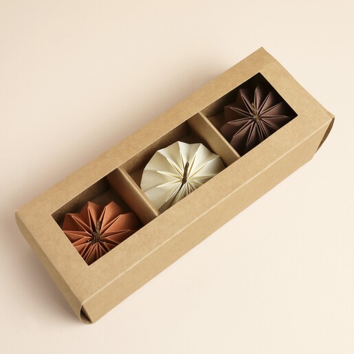 Trio of neutral paper pumpkin decorations displayed inside a kraft window box
