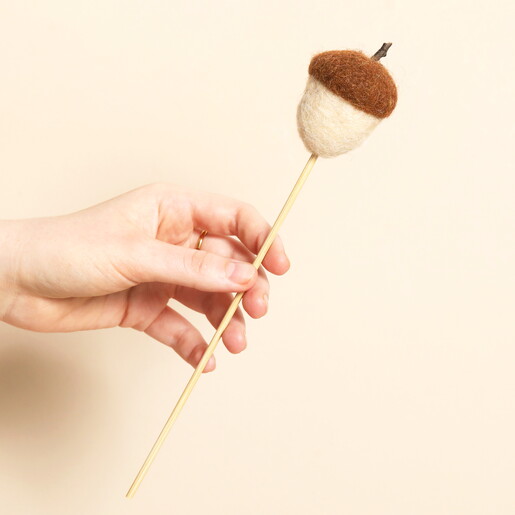 Full view of a felt acorn stick decoration held in hand