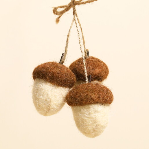 Close-up of three cream and brown felt acorns tied with natural twine