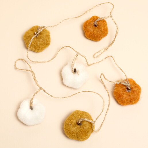 Overhead view of the mini felt pumpkin garland on a neutral background