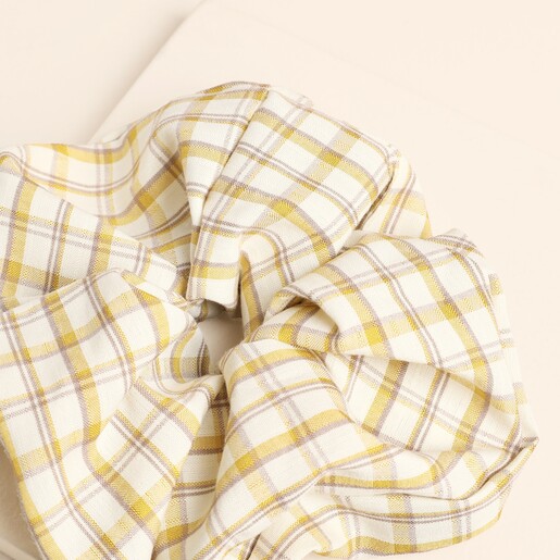 Close-up of the ruffled yellow gingham fabric of the oversized hair scrunchie