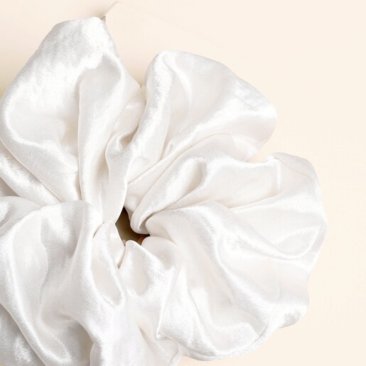 Close-up of the smooth gathered fabric on the white satin scrunchie