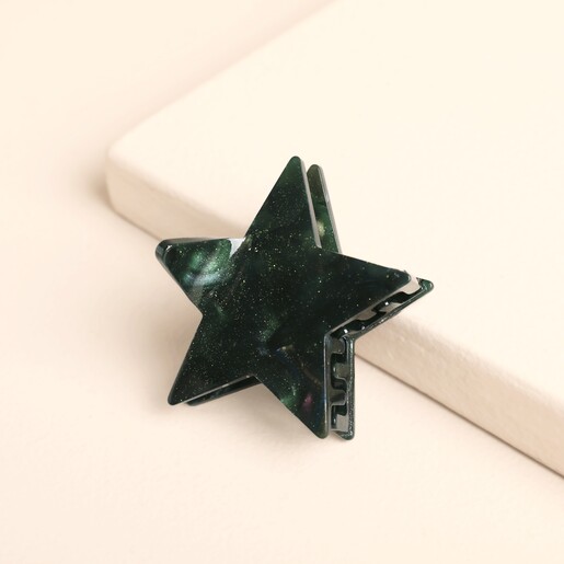 Top view of shimmering green star resin claw hair clip