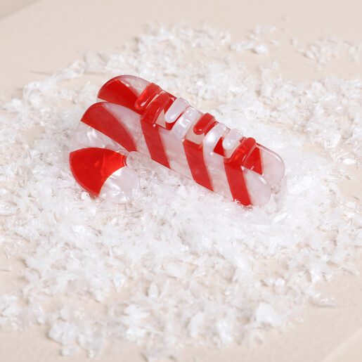 Close up angled view showing claw teeth of red and white candy cane hair clip