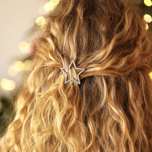 Rear view of woman with half-up wavy hairstyle accessorised with silver star hair clip