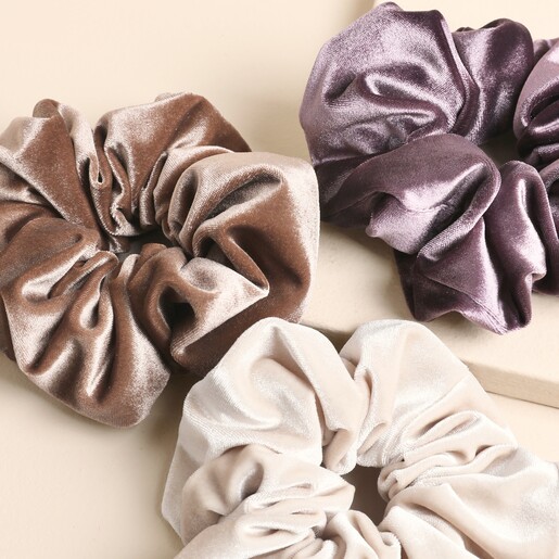 Close-up of three autumn-toned velvet hair scrunchies