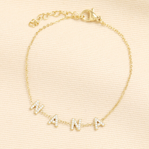 Gold stainless steel Nana crystal charm bracelet on beige fabric