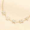 Close up view of clear crystal cubic zirconia MUMMY letter charms on gold trace chain