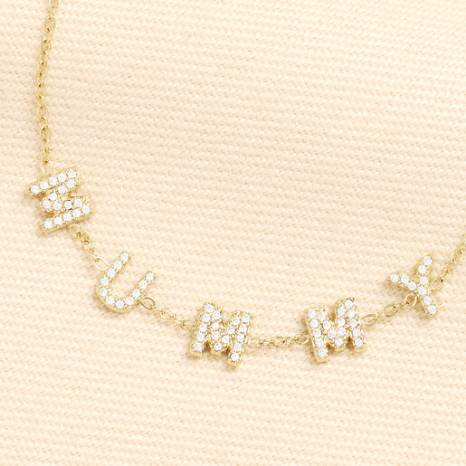 Close up view of clear crystal cubic zirconia MUMMY letter charms on gold trace chain
