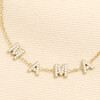 Close up of gold stainless steel bracelet showing crystal M A M A letter charms.