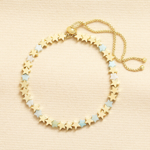 Gold star charm slider bracelet with pastel turquoise semi precious stone stars on neutral fabric