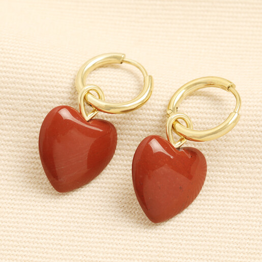 Gold stainless steel hoop earrings with glossy red jasper heart charms.