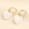 Gold hoop earrings featuring smooth white jade heart charms on hinge closures