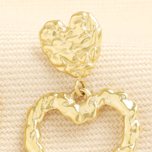 Close-up detail of gold stainless steel hammered double heart drop earring