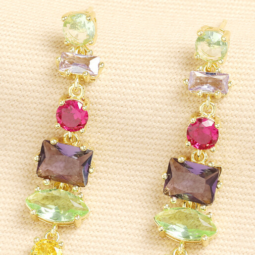 Close up of colourful multi-cut crystals on gold drop earrings