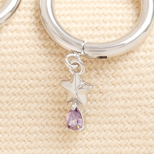 Close up of silver star charm huggie hoop earring with lilac crystal drop