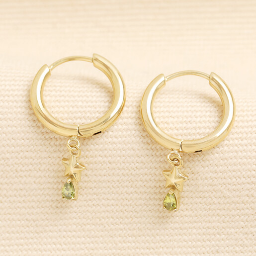 Pair of gold stainless steel huggie hoop earrings with star and green crystal charms