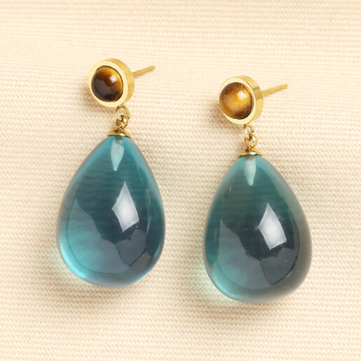 Gold drop earrings with tiger's eye stud and translucent blue resin teardrops.
