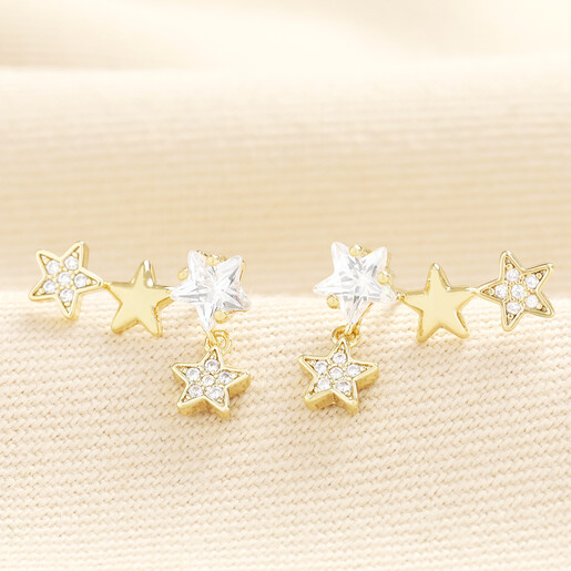 Pair of crystal triple star climber stud earrings in gold with dangling charm