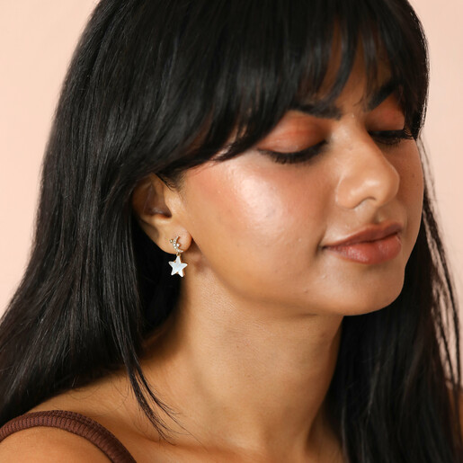model shot of star and moon drop earrings in gold