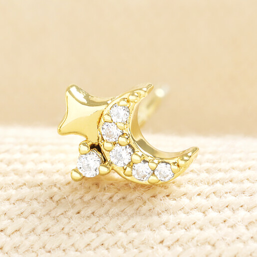 Close-up of gold moon and star tiny stud earring with sparkling crystals