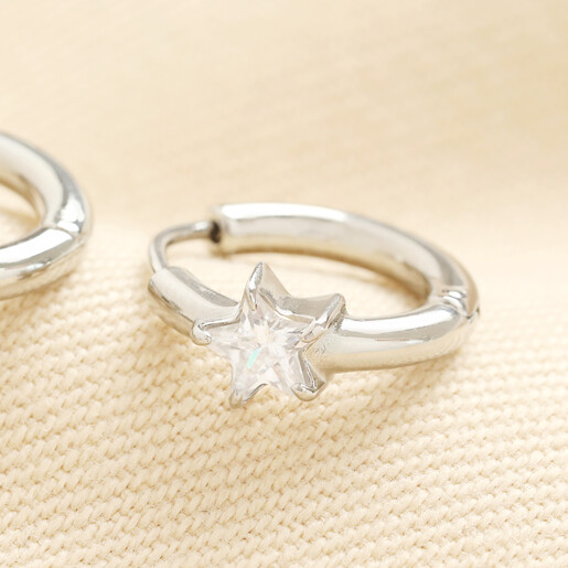Close up of silver huggie hoop earring featuring star shaped cubic zirconia crystal