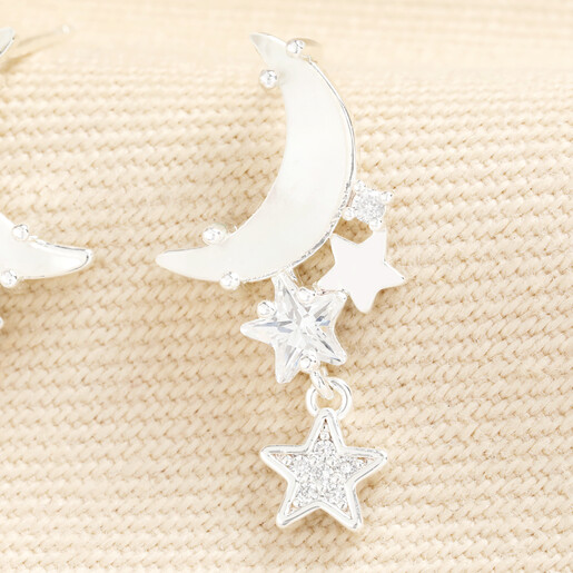 Close up of silver crescent moon and crystal star drop earring