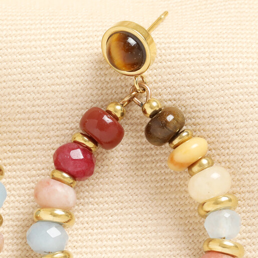 Close-up of beaded teardrop earring with smooth cabochon stud top