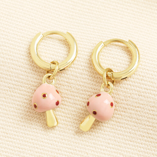 Pair of gold huggie hoop earrings with dangling pink enamel mushroom charms