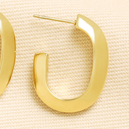 Close up view of a gold curved chunky hoop earring showing stud post
