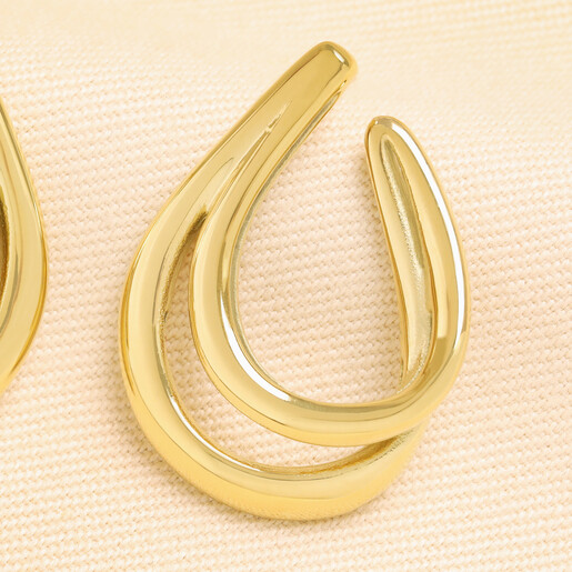 Close up of gold stainless steel double oval chunky hoop earring on cream fabric