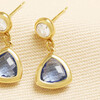 Close-up of gold stainless steel stud and faceted blue triangle glass charm