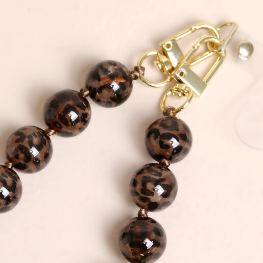 Close up of gold metal clasps on brown leopard print phone charm strap