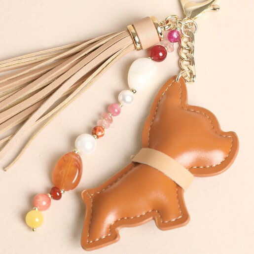Close-up of tan faux leather dog keyring with neutral tassel and colourful beaded charm
