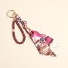 Red beaded semi-precious stone and patterned fabric keyring and bag charm on cream background
