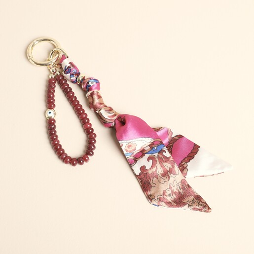 Red beaded semi-precious stone and patterned fabric keyring and bag charm on cream background