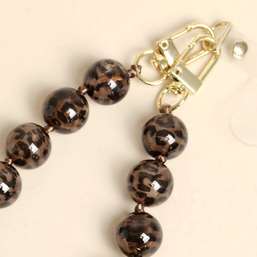 Close up of gold metal clasps on brown leopard print phone charm strap