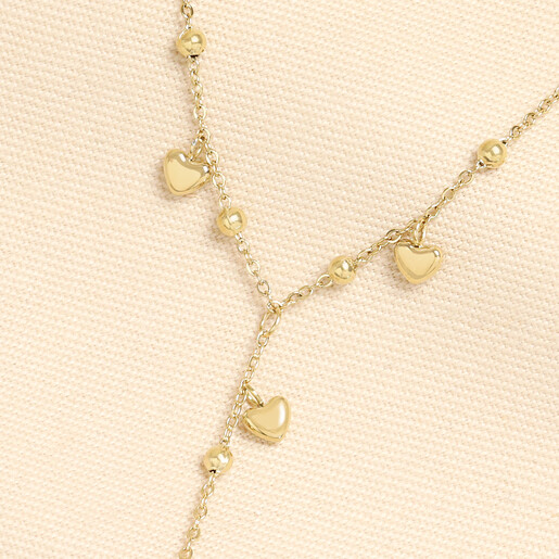 Close-up of gold stainless steel heart charms and beads on a fine Y-chain necklace.