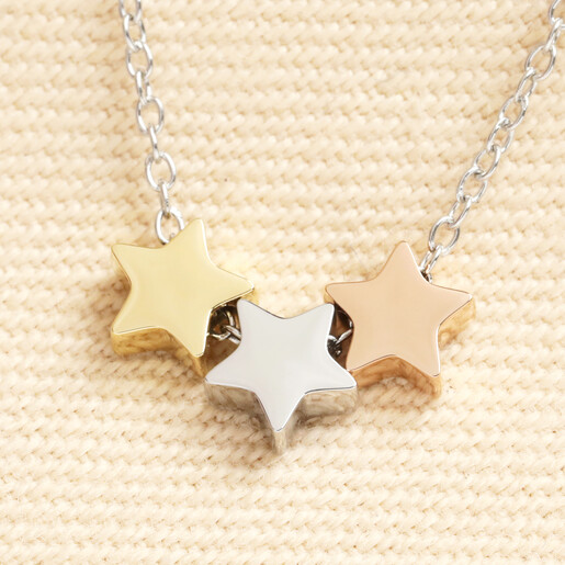 Close up of triple star pendant in contrasting silver, gold, and rose gold finishes