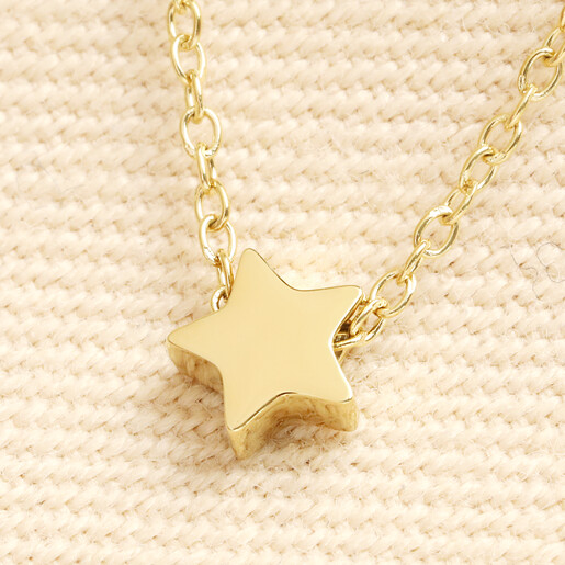 Close up of the gold stainless steel star charm on a fine trace chain