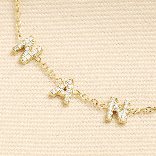 Close up of crystal encrusted letter charms on gold nanny necklace