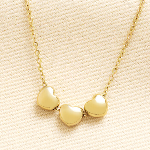 Gold stainless steel necklace with three linked heart charms on a delicate chain