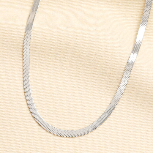 Silver stainless steel flat herringbone chain necklace draped on cream fabric