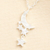 Close-up of mother of pearl crescent moon and crystal star charms in silver