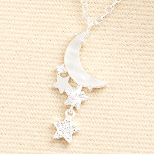 Close-up of mother of pearl crescent moon and crystal star charms in silver