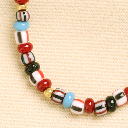 Close up detail of red, blue, and patterned glass beads with gold spacers