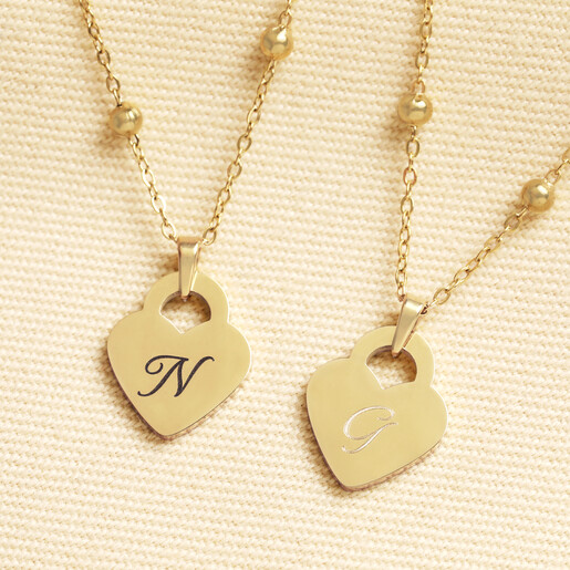 Gold stainless steel heart necklaces personalised with script swirl initials N and G