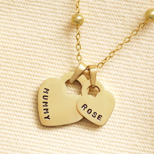 Close up of gold double heart charm engraved with Mummy and Rose
