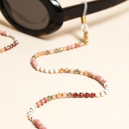 Close up of pink and red semi precious faceted beads on gold glasses chain